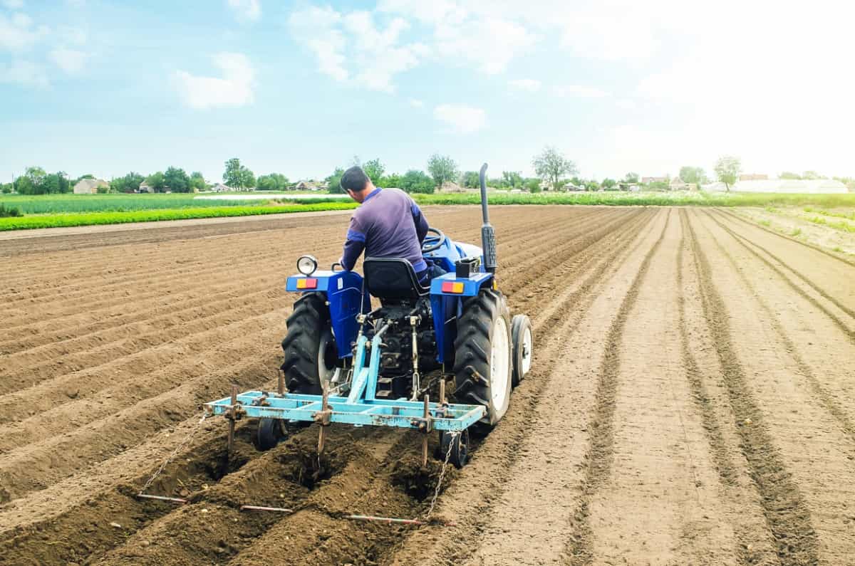 Farmer on A Tractor Making Rows on A Farm Field