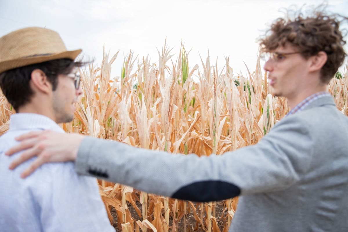 An Insurance Agent Talking to A Farmer in The Fields