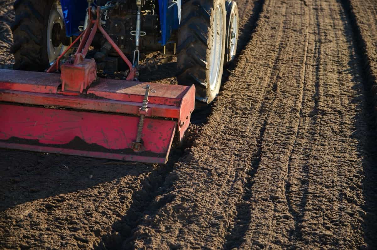tractor cultivator breaks up and mixes the soil