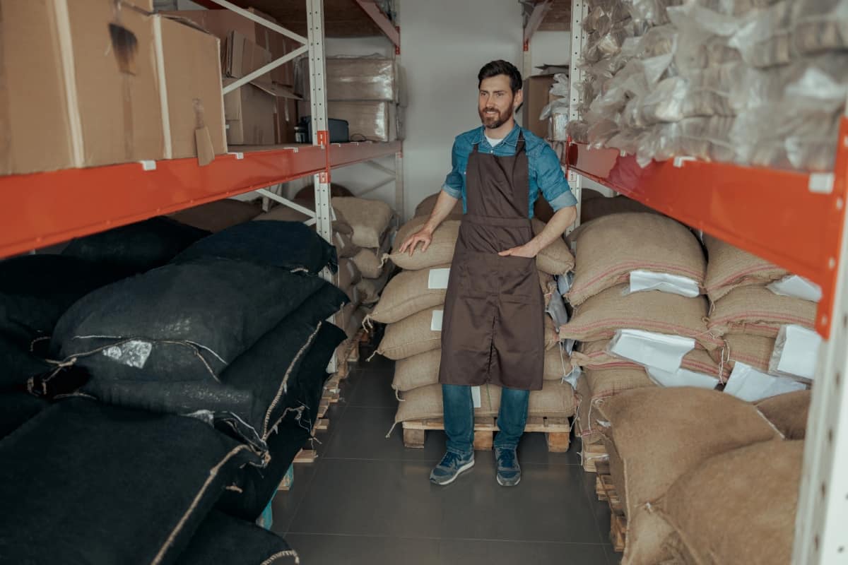 Warehouse Worker Inspecting Bags with Coffee Beans