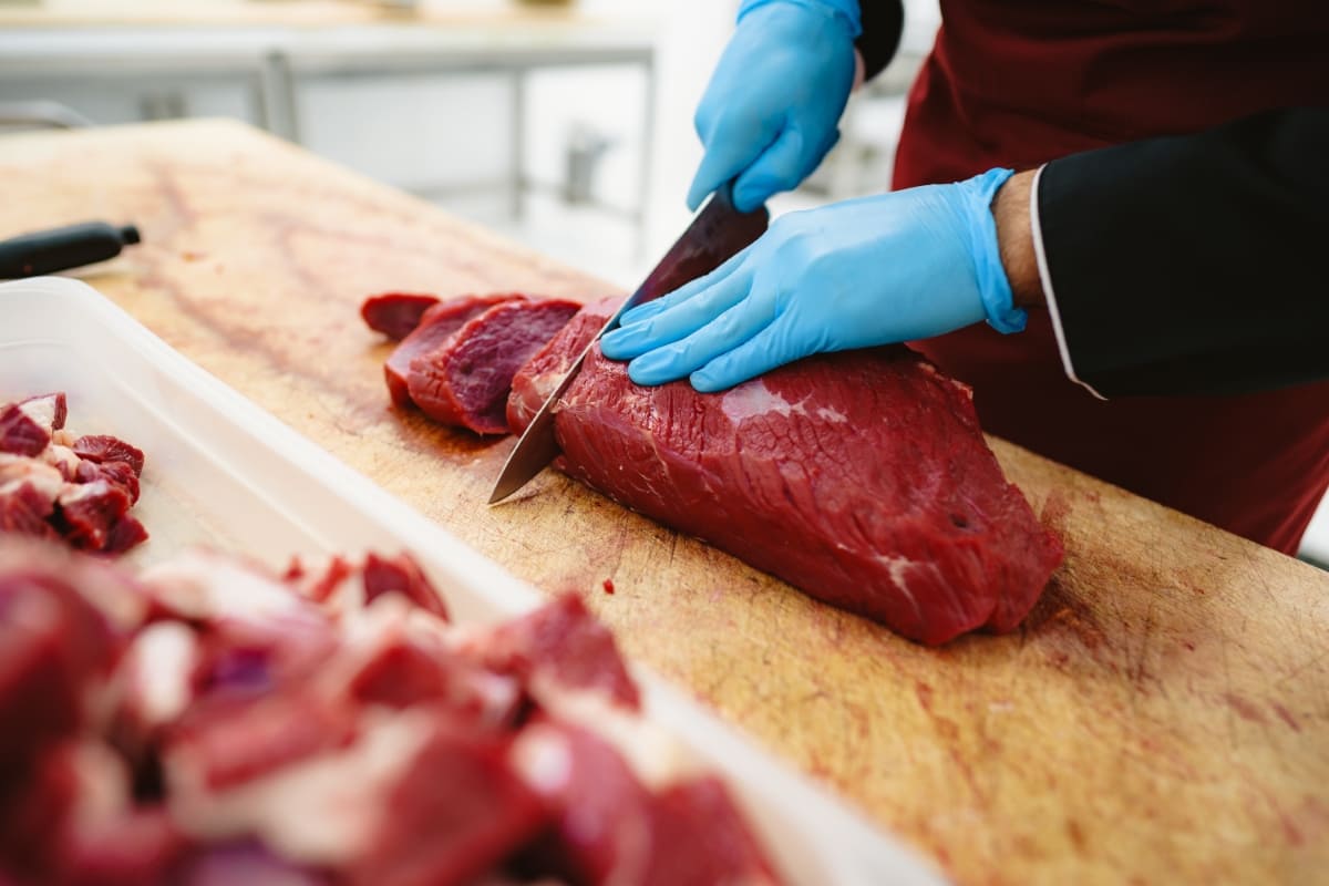 Butcher Cutting Slices of Raw Meat